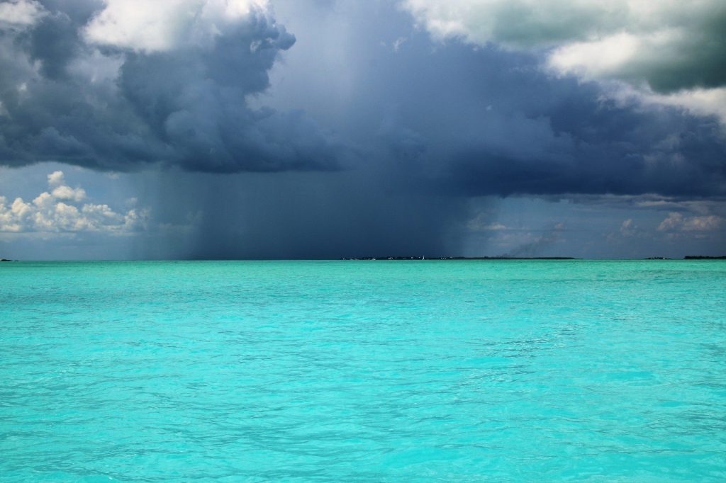 dark rain storm coming down in one spot over the beautiful turquoise waters of the Caribbean ocean