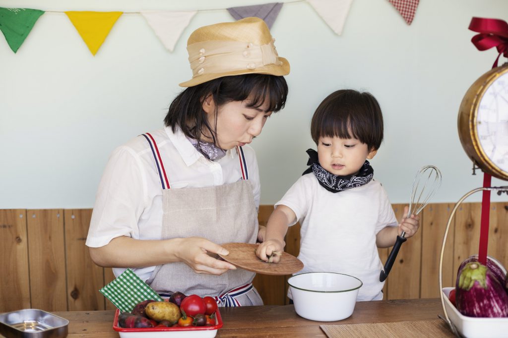 Japanese woman and boy standing in a farm shop, preparing food.